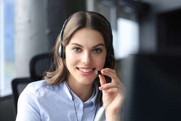 Female customer support operator with headset and smiling. - obrazy, fototapety, plakaty