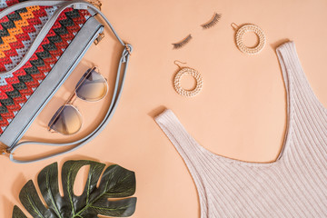 Beauty concept in a blog.Women's summer accessories, false eyelashes.Female background and fashion. Exotic green leaf of palm tree. on a pink background.Fashion or summer holiday concept.Flat lay