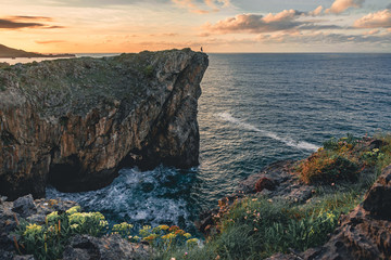Landscape with silhouette of a man standing on the edge of cliff on the sea coast in north Spain, Asturias, Europe