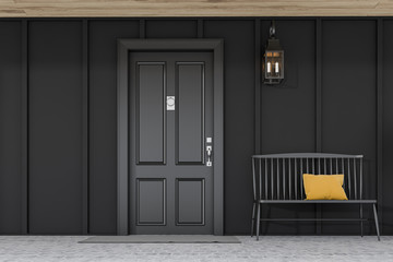 Black front door of black house with bench