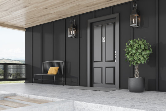 Black door of black house, tree and bench