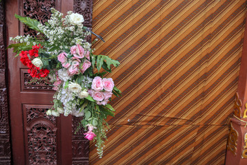 Fototapeta na wymiar Pattern East West and Central Java on fabric with pink and red flower hang over for wedding party