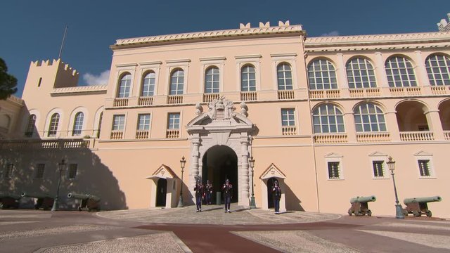 Guards marching at entrance of Prince's Palace of Monaco in city on sunny day - Monte Carlo, Monaco
