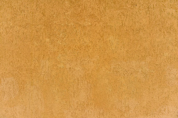 The wall of the building with a speckled surface of clay stucco beige brown. Background