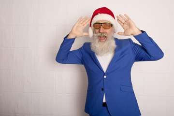 Dancing Santa Claus over white. Senior bearded man in blue suit in red hat. Xmas.