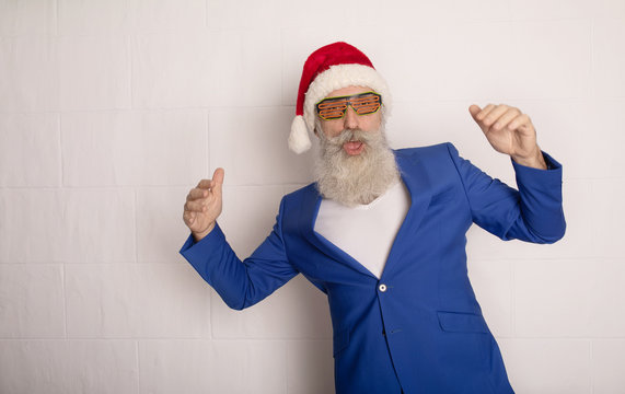 Dancing Santa Claus over white. Senior bearded man in blue suit in red hat. Xmas.