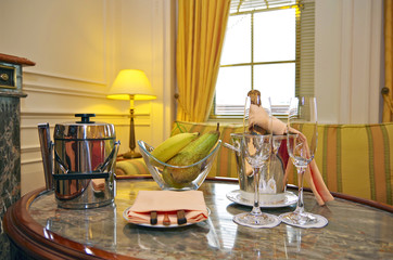 Set of welcome champagne, glasses and fruit basket and ice bucket on marble table in luxury cabin...