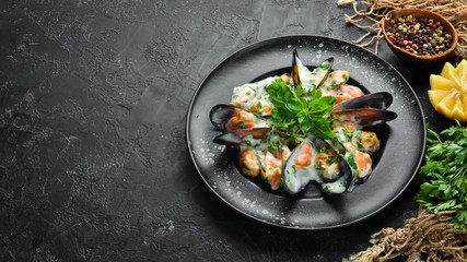 Mussels in cream sauce with basil. In the old background. Top view. Free copy space.