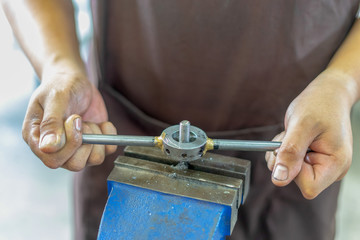 Old tools ,Mechanic using Taps and Dies tool Making Internal and External Threads nut at motorcycle garage .selective focus