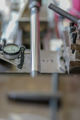 Dial gauge when measuring shaft with cogwheel. Close-up of measurement by probe indicator 