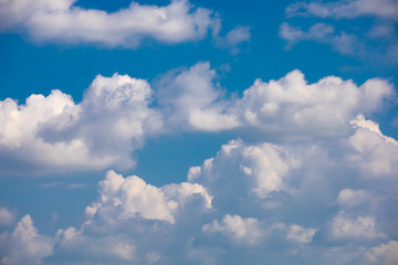 The white fluffy clouds and light blue sky in the sunny day. 