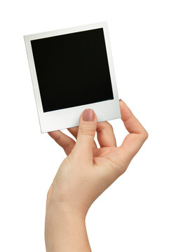 female hand holding polaroid frame on white background