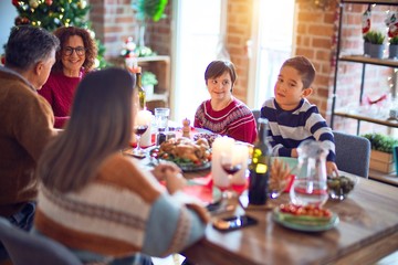 Beautiful family smiling happy and confident. Eating roasted turkey celebrating christmas at home