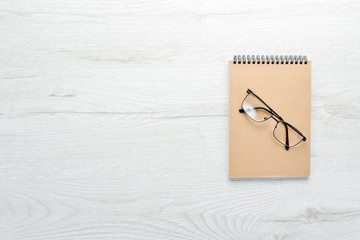 White office desk table with notepad and office supplies. Top view with copy space, flat lay.