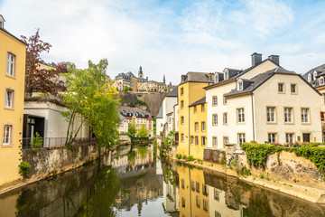 Fototapeta na wymiar Alzette river bend with houses reflected in water and cathedral on the hill, Luxembourg city, Luxembourg