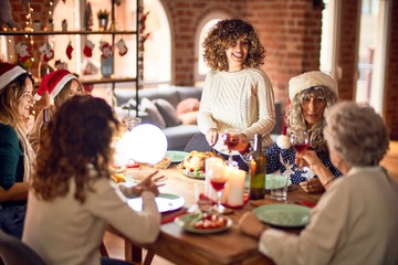 Beautiful group of women smiling happy and confident. Carving roasted turkey celebrating christmas at home