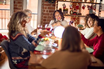 Beautiful group of women smiling happy and confident. Eating roasted turkey celebrating christmas at home