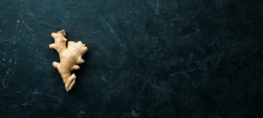 Fresh ginger root on stone background. Vitamins. Top view. Free space for your text.