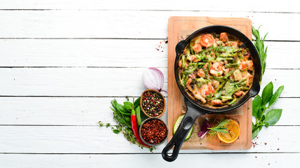 Baked beef with beans, tomatoes and vegetables in a frying pan. Top view. Free space for your text.