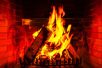 Fototapety  Wood burning in a cozy fireplace at home in interior.