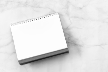 White blank paper desk spiral calendar on marble background.