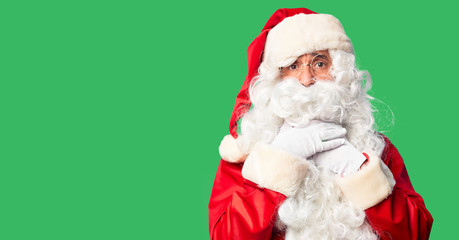 Middle age handsome man wearing Santa Claus costume and beard standing shouting suffocate because painful strangle. Health problem. Asphyxiate and suicide concept.