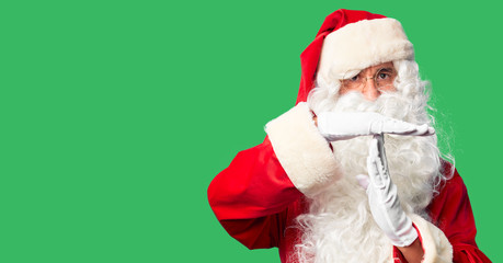 Middle age handsome man wearing Santa Claus costume and beard standing Doing time out gesture with...