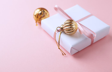 Christmas baubles and Christmas present. Bright paper background. Copy space. 