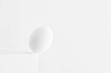 Egg standing on the edge of a table and falling down on white background