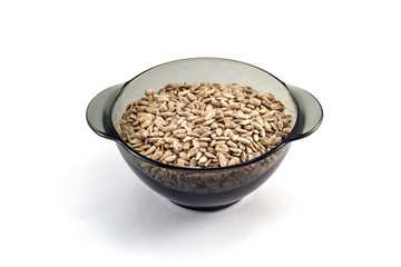Sunflower seeds in a black transparent plate on a white background
