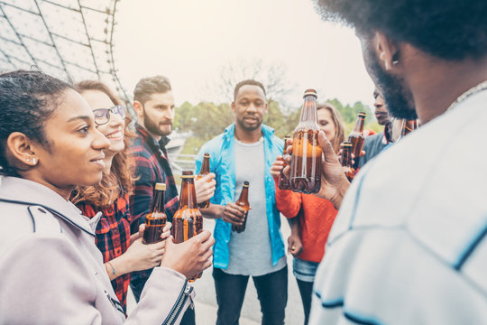 Diverse group of friends enjoying a beer in the park