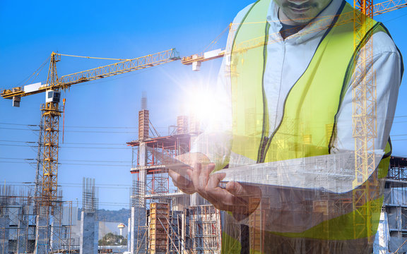 The architect is working and holding a blueprint in hand to inspect the  construction site  according to plan, conceptual picture of new building business industry.