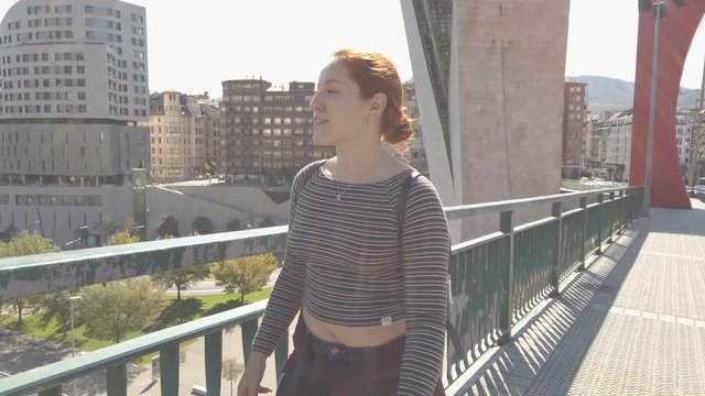 Young woman contemplating the views of the Bilbao city and the Nervion River stacked on the railing