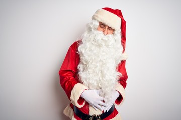 Middle age handsome man wearing Santa costume standing over isolated white background with hand on stomach because indigestion, painful illness feeling unwell. Ache concept.