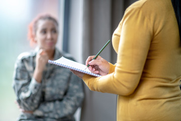 Female psychoanalyst wearing yellow sweater making notes