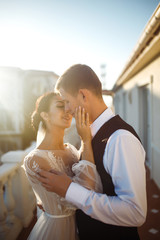 The ring on a the finger. Pretty bride and stylish groom are enjoying each other. A bridegroom in a black suit gently embraces a beautiful bride in a white dress. Relationship love concept. Together. 