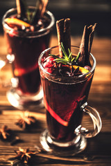 Mulled wine with spices in glasses on a rustic wooden table. Winter drink traditional for the...