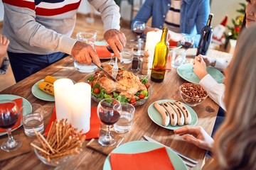 Beautiful family meeting smiling happy and confident. Carving roasted turkey celebrating Christmas at home