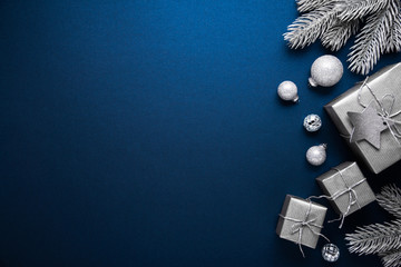 Merry Christmas and Happy Holidays greeting card, frame, banner. New Year. Noel. Christmas ornaments and gift on blue background top view. Winter xmas holiday theme. Flat lay	