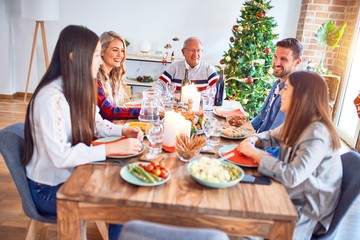 Beautiful family meeting smiling happy and confident. Eating roasted turkey celebrating Christmas at home