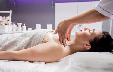 Fototapeta na wymiar Beautiful young woman enjoying massage in spa salon. Cosmetology