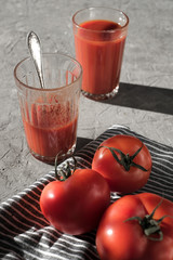 Glass of fresh tomato juice, tomatoes and garlic  on a dark   board