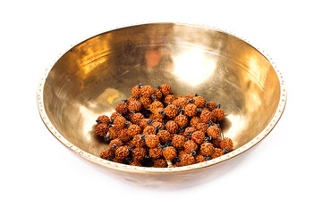Closeup of a singing bowl and a japamala on a white backround