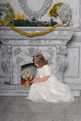 girl in a white dress and a fur coat by the old fireplace in the interior