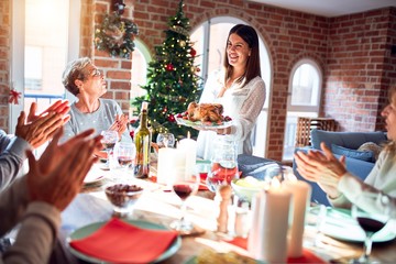 Family and friends dining at home celebrating christmas eve with traditional food and decoration, showing proud turkey cooking