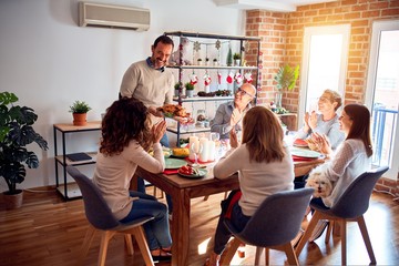 Family and friends dining at home celebrating christmas eve with traditional food and decoration, showing proud turkey cooking