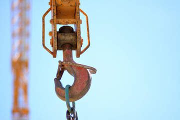 Construction crane hook in the blue sky.