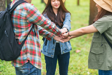 Closeup image of people putting their hands together in the outdoors