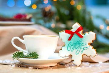 Christmas and happy new year card with cup of coffee, pine, fir branch and gingerbread on wooden table background, copy space, top view