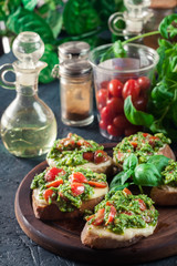 Bruschetta with fresh pesto, mozzarella and cherry tomatoes on cutting board